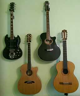 E-Gitarre, 12saitige Western-Gitarre, 6saitige Western-Gitarre und Konzertgitarre an der Wand hängend